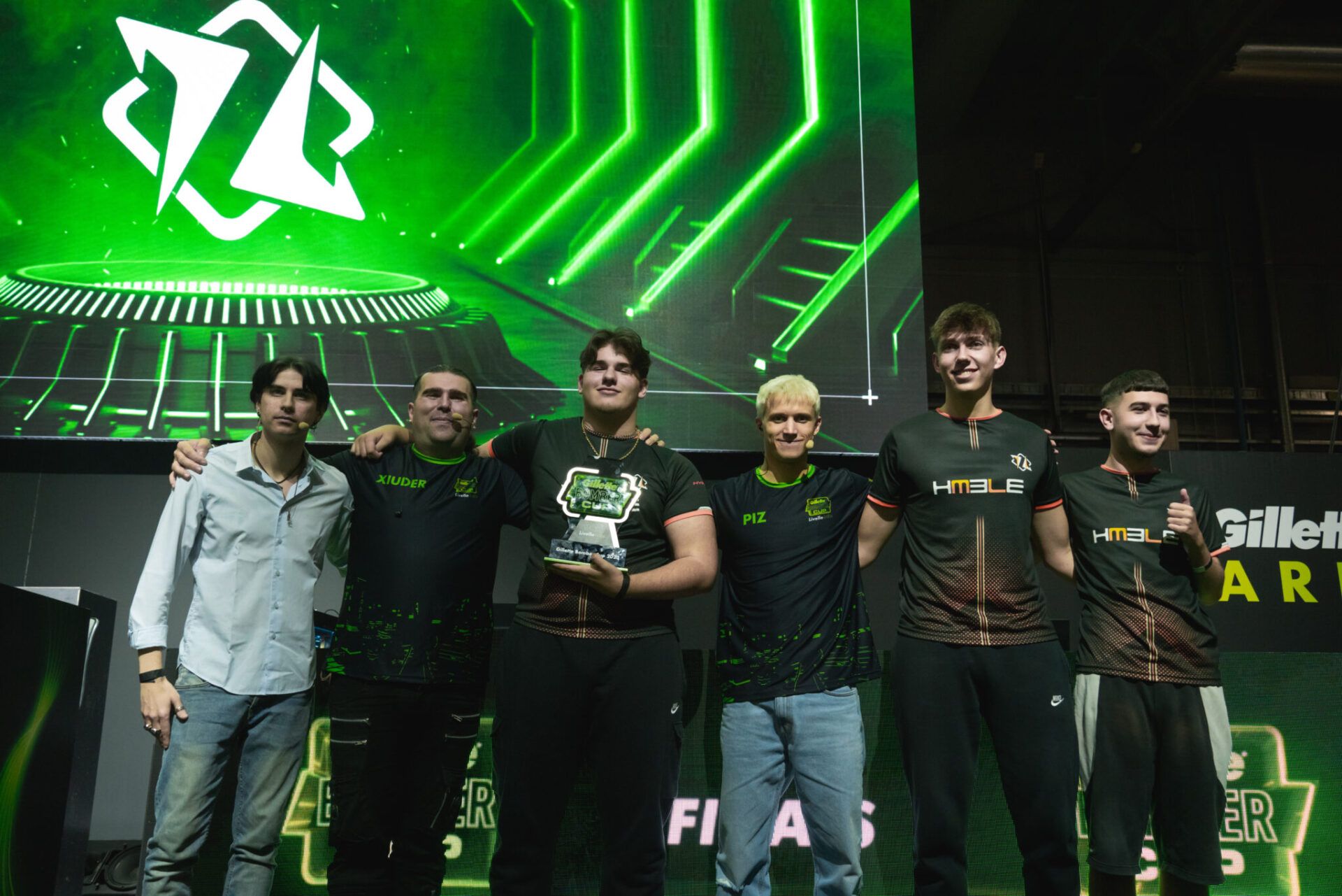 Team di eSports celebra una vittoria in un evento importante, schermo verde sullo sfondo. 10085886