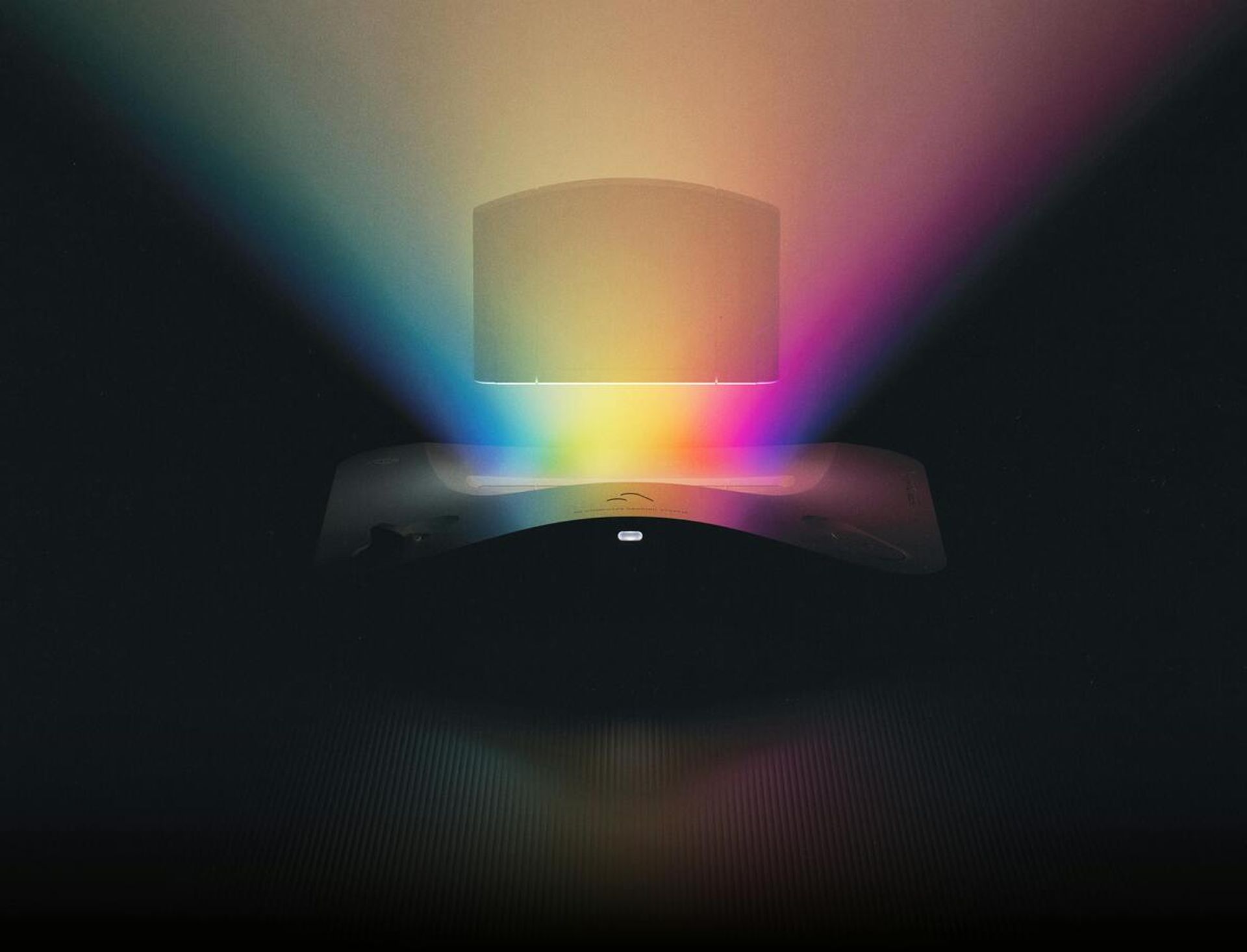 Console di gioco con effetti di luce arcobaleno su uno sfondo scuro suggestivo.